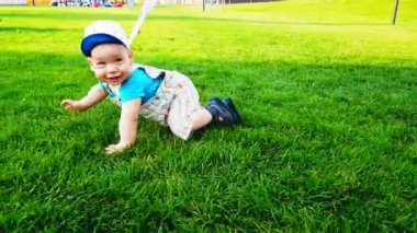 Sıcak bir yaz gününde parlak yeşil çimenler üzerinde sürünen iki bebek