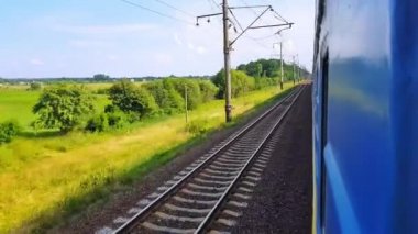Tepeler ve ormanile güzel bir manzara üzerinde yüksek hızlı tren manzarası. Arabanın penceresinden manzara, otobüs, tren. Güneşli bir günde trenden yolculuk