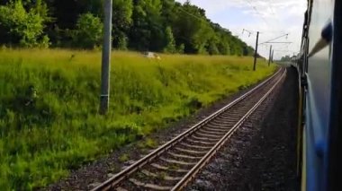 Binek spor araba bir alan yolda bir yolcu treni sollar Arabanın penceresinden görünümü, otobüs, tren. Güneşli bir günde trenden yolculuk