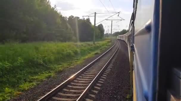 Yolcu treni sola dönüyor. Arabanın penceresinden manzara, otobüs, tren. Güneşli bir günde trenden yolculuk — Stok video