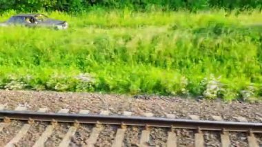 Binek spor araba bir alan yolda bir yolcu treni sollar Arabanın penceresinden görünümü, otobüs, tren. Güneşli bir günde trenden yolculuk