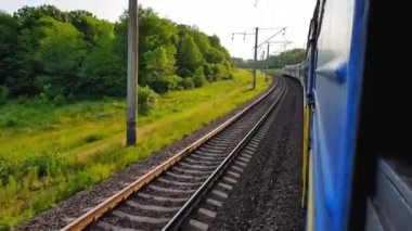 Yolcu treni sola dönüyor. Arabanın penceresinden manzara, otobüs, tren. Güneşli bir günde trenden yolculuk