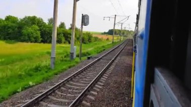 Tepeler ve ormanile güzel bir manzara üzerinde yüksek hızlı tren manzarası. Arabanın penceresinden manzara, otobüs, tren. Güneşli bir günde trenden yolculuk