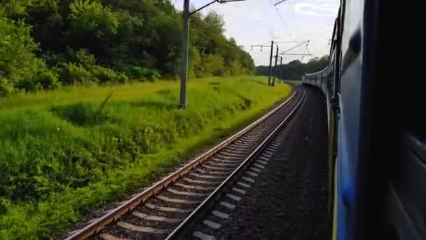 Yolcu treni sola dönüyor. Arabanın penceresinden manzara, otobüs, tren. Güneşli bir günde trenden yolculuk — Stok video