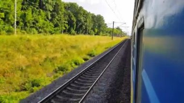 Tepeler ve ormanile güzel bir manzara üzerinde yüksek hızlı tren manzarası. Arabanın penceresinden manzara, otobüs, tren. Güneşli bir günde trenden yolculuk