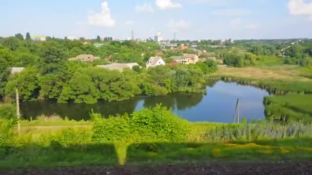 The view from the high-speed train on the beautiful scenery with hills, lake and forest. The view from the window of the car, bus, train. Journey from the train on a sunny day — Stock Video