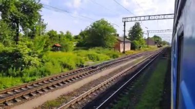 Tepeler ve ormanile güzel bir manzara üzerinde yüksek hızlı tren manzarası. Arabanın penceresinden manzara, otobüs, tren. Güneşli bir günde trenden yolculuk