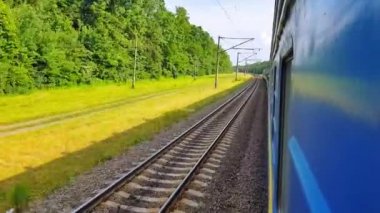 Yolcu treni sola dönüyor. Arabanın penceresinden manzara, otobüs, tren. Güneşli bir günde trenden yolculuk