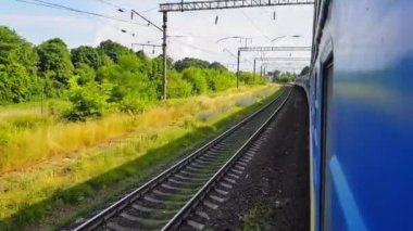 Yolcu treni sola dönüyor. Arabanın penceresinden manzara, otobüs, tren. Güneşli bir günde trenden yolculuk