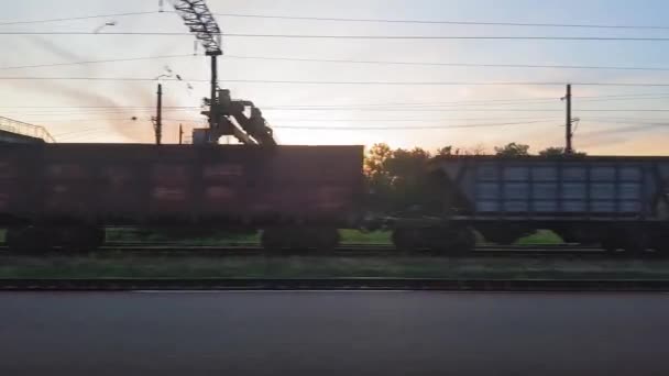 Der Blick aus dem Zug auf die schöne Landschaft mit Hügeln und Wäldern vor Sonnenuntergang. der Blick aus dem Fenster des Autos, Busses, Zuges. Anreise vom Zug. — Stockvideo