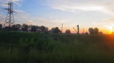 Gün batımından önce tepeler ve orman ile güzel bir manzara üzerinde trenden görünümü. Arabanın penceresinden manzara, otobüs, tren. Trenden yolculuk.