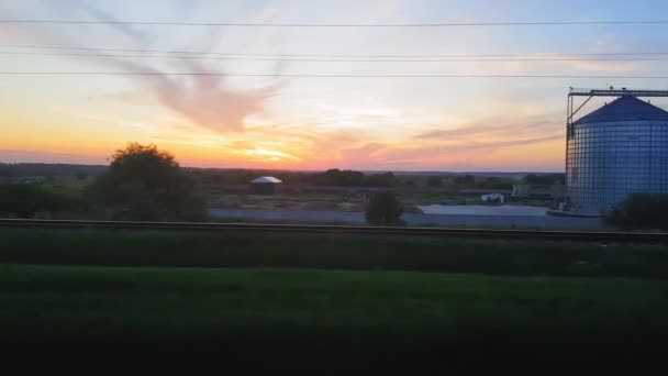 La vista desde el tren en el hermoso paisaje con colinas y bosques antes del atardecer. La vista desde la ventana del coche, autobús, tren. Viaje desde el tren . — Vídeos de Stock