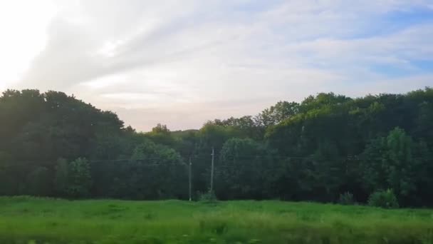 La vista dal treno sullo splendido scenario con colline e boschi prima del tramonto. La vista dal finestrino della macchina, autobus, treno. Viaggio dal treno . — Video Stock