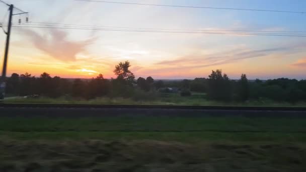 Het uitzicht vanaf de trein op het prachtige landschap met heuvels en bos voor zonsondergang. Het uitzicht vanuit het raam van de auto, bus, trein. Reis van de trein. — Stockvideo