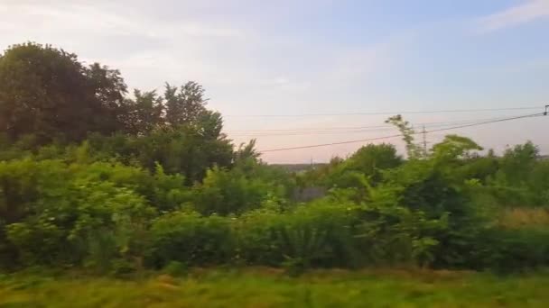 Gün batımından önce tepeler ve orman ile güzel bir manzara üzerinde trenden görünümü. Arabanın penceresinden manzara, otobüs, tren. Trenden yolculuk. — Stok video