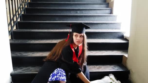 Όμορφη φοιτήτρια μεταπτυχιακός δάσκαλος ταινίες το πόδι της με ένα γύψο, ενώ κάθονται σε μεταλλικά βήματα στο Πανεπιστήμιο — Αρχείο Βίντεο