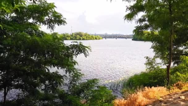 Pohled na řeku Dnieper od vysokého břehu, sledovací záběr za stromem. — Stock video