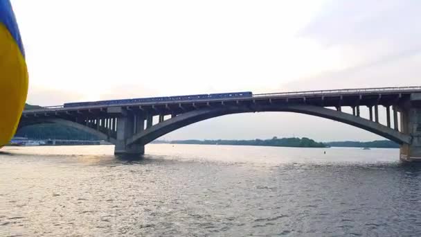 4K, le navire navigue sur le large fleuve du Dniepr avec de grands ponts avant le coucher du soleil 