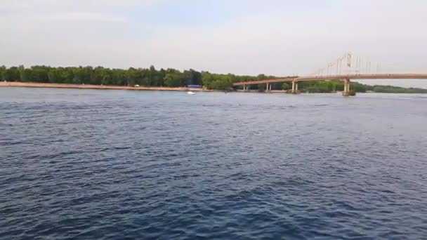 4K, el barco navega en el ancho río del Dniéper con grandes puentes antes de la puesta del sol — Vídeo de stock