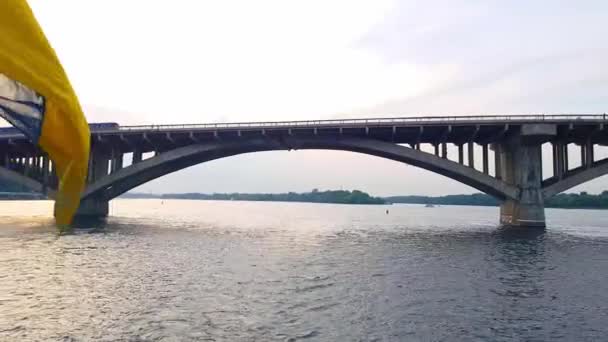4K, le navire navigue sur le large fleuve du Dniepr avec de grands ponts avant le coucher du soleil 