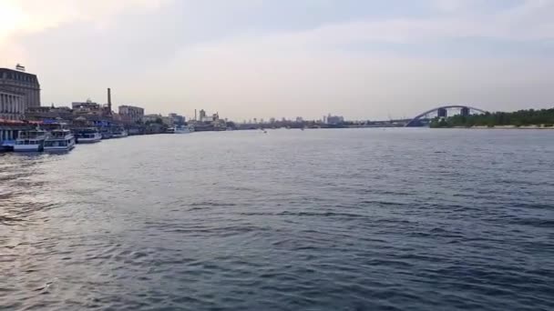 4k, het schip vaart op de brede rivier van de Dnjepr met grote bruggen voor de zonsondergang — Stockvideo