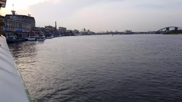 4k, het schip vaart op de brede rivier van de Dnjepr met grote bruggen voor de zonsondergang — Stockvideo