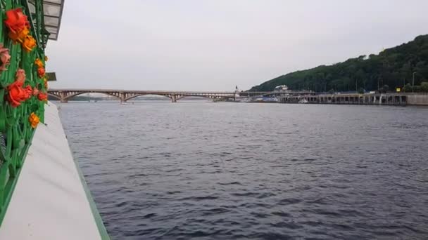 4K, fartyget seglar på den breda floden av Dnepr med stora broar före solnedgången — Stockvideo