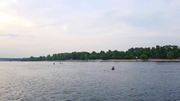 4k, het schip vaart op de brede rivier van de Dnjepr met grote bruggen voor de zonsondergang — Stockvideo