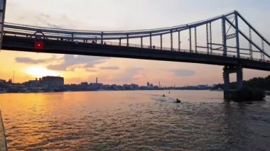 4k. gün batımı öncesinde büyük köprüler ile geniş nehir Dinyeper üzerinde gemi yelken