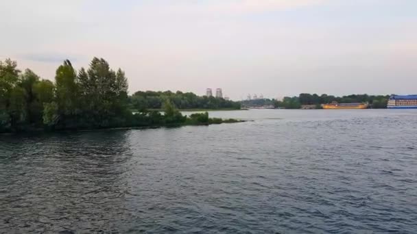 4K. El barco navega por el ancho río Dnieper con grandes puentes antes del atardecer — Vídeo de stock