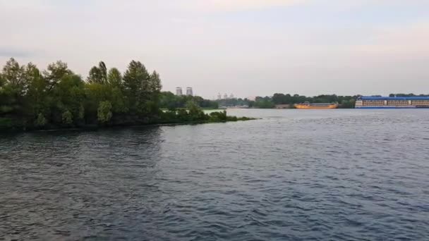 4K. statek żagle na szerokiej rzece Dnieper z dużymi mostami przed zachodem słońca — Wideo stockowe