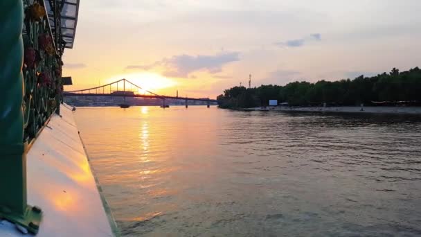 4k. Das Schiff fährt auf dem breiten Fluss Dnjepr mit großen Brücken vor Sonnenuntergang — Stockvideo