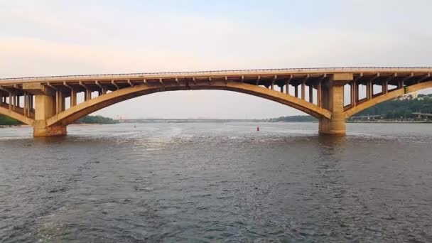 4K. El barco navega por el ancho río Dnieper con grandes puentes antes del atardecer — Vídeo de stock