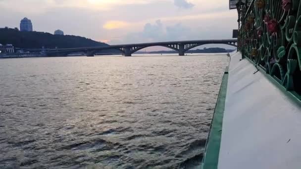 4K. El barco navega por el ancho río Dnieper con grandes puentes antes del atardecer — Vídeos de Stock