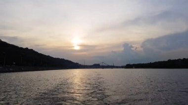 4k. gün batımı öncesinde büyük köprüler ile geniş nehir Dinyeper üzerinde gemi yelken