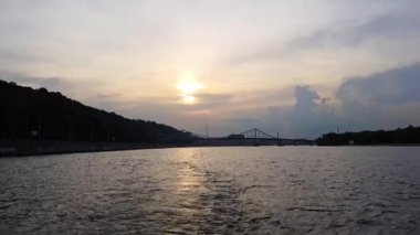 4k. gün batımı öncesinde büyük köprüler ile geniş nehir Dinyeper üzerinde gemi yelken