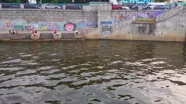 4K. El barco navega cerca del terraplén y del puerto fluvial en el río Dniéper antes del atardecer. — Vídeos de Stock