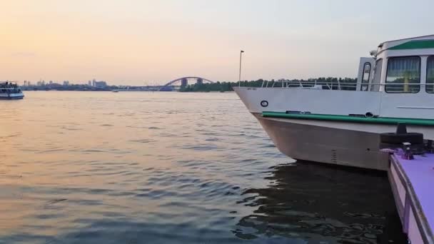 4K. Le navire navigue sur la large rivière Dniepr avec de grands ponts avant le coucher du soleil — Video