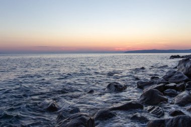Deniz dalgası, Holy Mount Athos sahilinin yakınında gün batımında taşlar vurur
