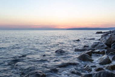 Deniz dalgası, Holy Mount Athos sahilinin yakınında gün batımında taşlar vurur