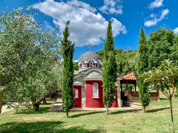 Una pequeña iglesia en el Monte Athos con paredes rojas, azulejos con un baptisterio y una campana —  Fotos de Stock