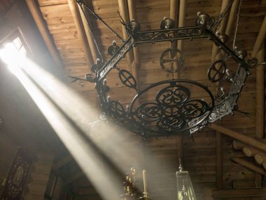 Güneş ışınları tahttaki Ortodoks kilisesinin pencerelerinden ve çatlaklarından ve kutsal nesnelerden geçiyor.