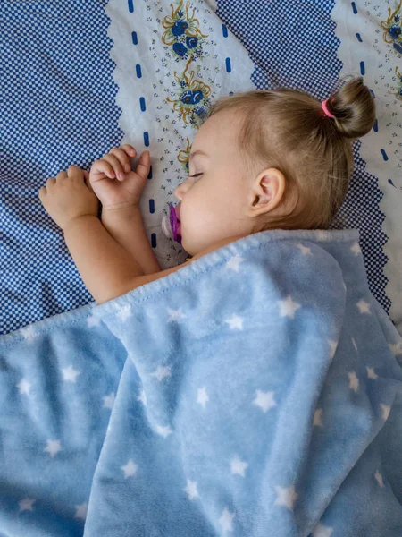 Bir kukla ile yatakta küçük kız görünümü yukarıda — Stok fotoğraf