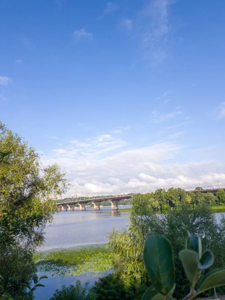 Široká řeka Dnieper s mostem po východu slunce s nádherními mraky — Stock fotografie