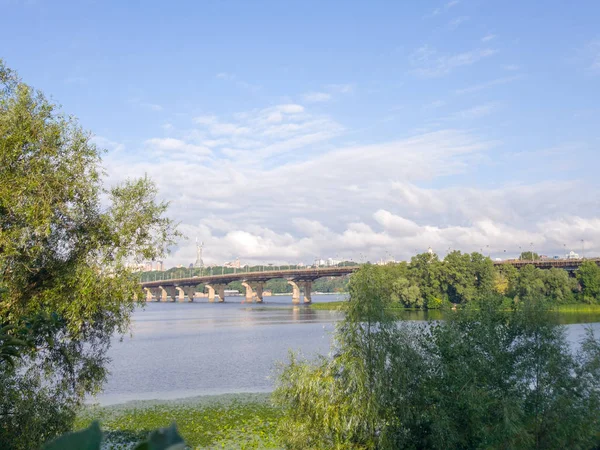 Široká řeka Dnieper s mostem po východu slunce s nádherními mraky — Stock fotografie