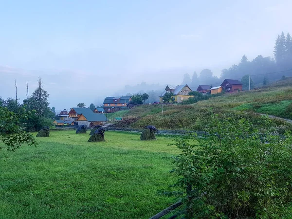 Karpat dağlarında yaz gün doğumu. Dağ vadisinde pitoresk sabah manzarası. Sanatsal tarzı sonrası işlenmiş fotoğraf. Doğa kavramı arka plan güzelliği. küçük bir köy