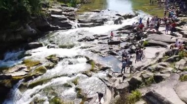 Taşlar arasında su akıntısı akar. Berrak su hızla karanlık ıslak taşlar etrafında akan yokuş aşağı düşmek. Siyah kayalarakan şelalenin yakın çekim. Güzel dağ şelalesi