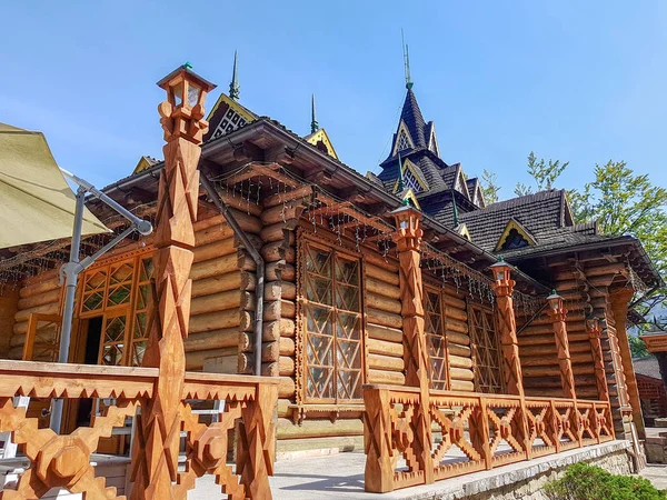 Une maison en bois sur une prairie verdoyante en montagne. Une maison près de la vieille forêt. Mode de vie dans le village des Carpates . — Photo