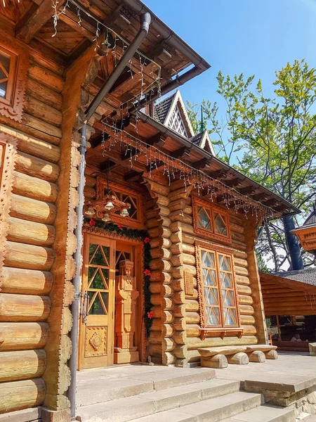 Une maison en bois sur une prairie verdoyante en montagne. Une maison près de la vieille forêt. Mode de vie dans le village des Carpates . — Photo