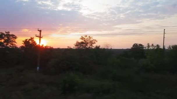 Widok z pociągu na pięknej scenerii z wzgórzami i lasem po wschodzie słońca. Widok z okna samochodu, autobusu, pociągu. Podróż z pociągu. — Wideo stockowe